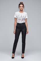Woman wearing a white t-shirt with graphic design and black pants on a gray background