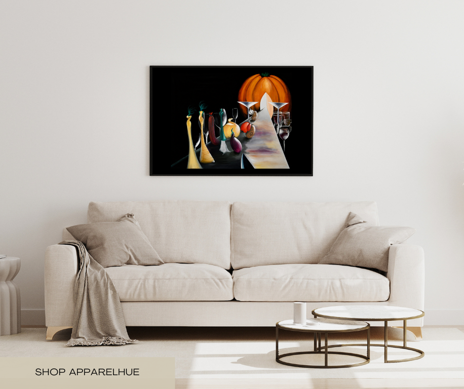 A framed wall art print depicting a stylized still life with a glowing orange pumpkin and dark figures, displayed above a cream-colored sofa in a modern living room setting.