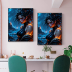 Two vertical framed wall art prints hang on a pale pink wall above a dining table with green chairs. Each print shows a stylized fantasy portrait of a woman with dark hair, glowing orange flames, and a blue ocean or fiery landscape background.