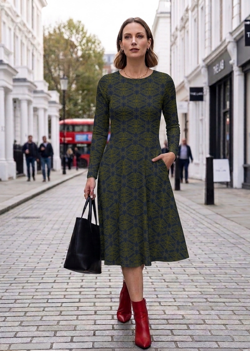 Woman in a patterned dress with red shoes walking on a city street.