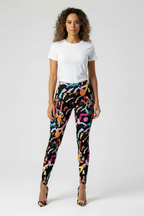 Woman wearing colorful patterned leggings and a white t-shirt on a white background