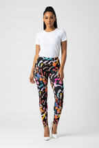 Woman wearing colorful patterned leggings and a white t-shirt on a white background