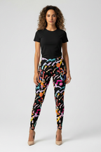 Woman wearing black t-shirt and colorful patterned leggings on a white background
