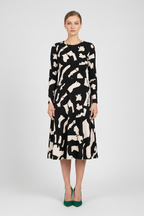 Woman wearing a black and white patterned dress on a white background