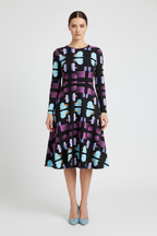 Woman wearing a patterned dress on a white background