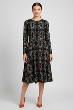 Woman wearing a patterned dress on a plain background