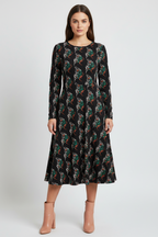 Woman wearing a black floral patterned dress on a white background