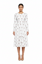 Woman wearing a white dress with red floral pattern on a white background