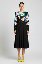 Woman wearing a black dress with a colorful abstract pattern on a white background