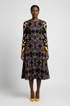 Woman wearing a colorful patterned dress on a white background