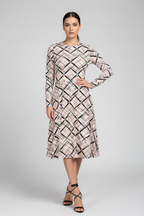 Woman wearing a patterned dress on a gray background