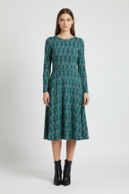 Woman wearing a green patterned dress on a white background