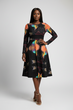 Woman wearing a black dress with colorful abstract patterns on a white background