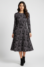 Woman wearing a black and white patterned dress on a white background