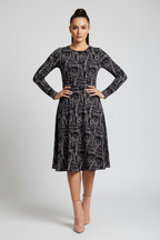 Woman wearing a black patterned dress on a white background