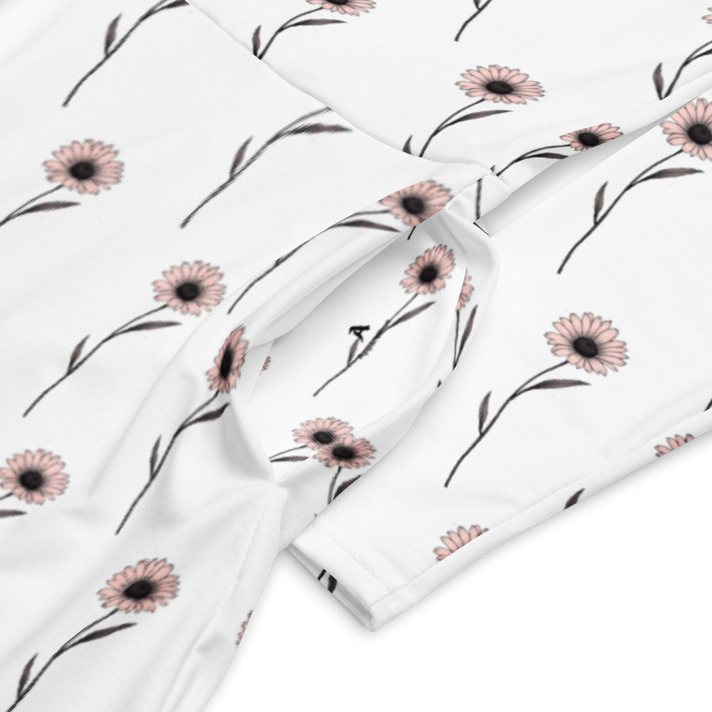 Floral-patterned fabric with pink flowers and green leaves on a white background