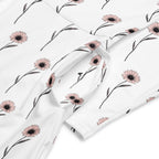 Floral-patterned fabric with pink flowers and green leaves on a white background