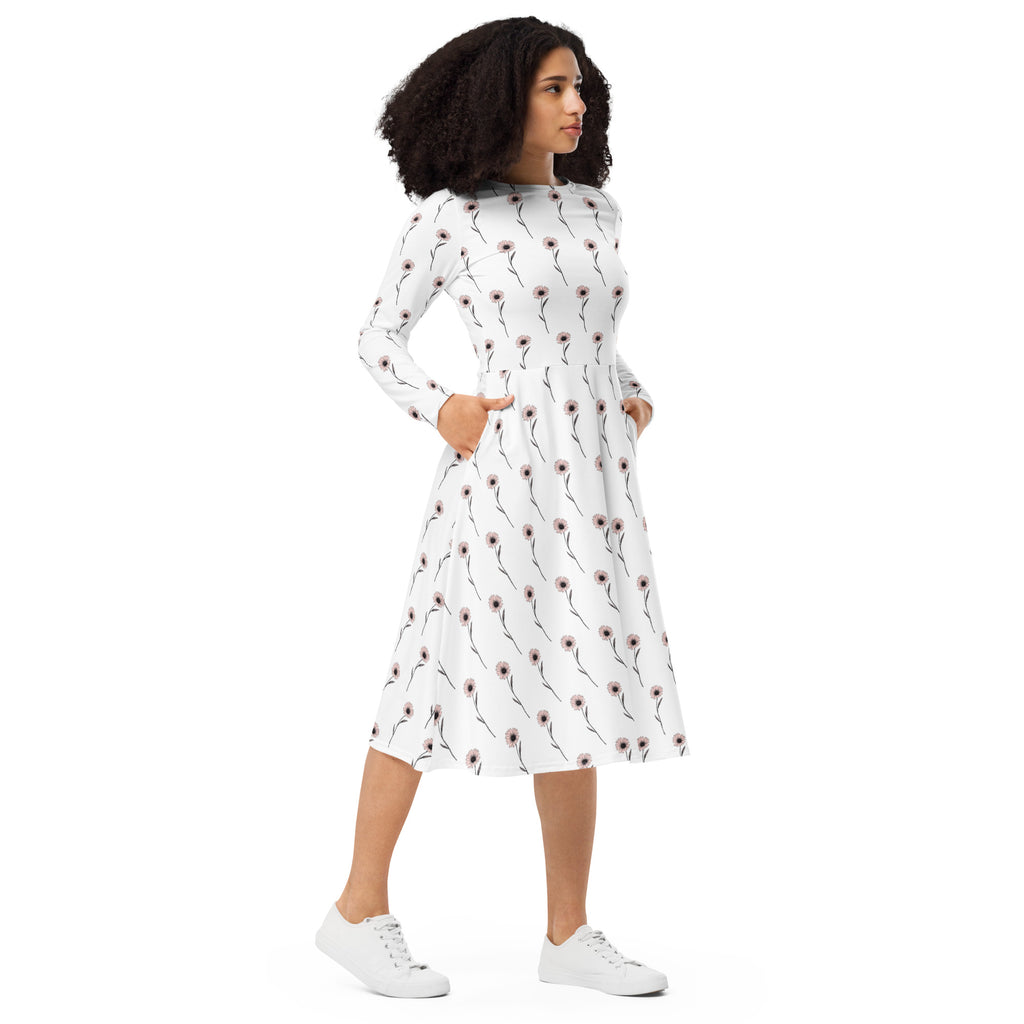Woman wearing a white dress with a pattern, standing against a white background