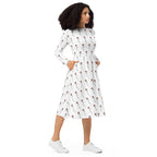 Woman wearing a white dress with a pattern, standing against a white background