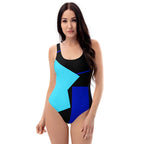 A full-body front view of a model wearing a geometric color block one-piece swimsuit with a bold design.