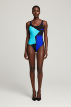 Model wearing a colorful geometric swimsuit on a plain background