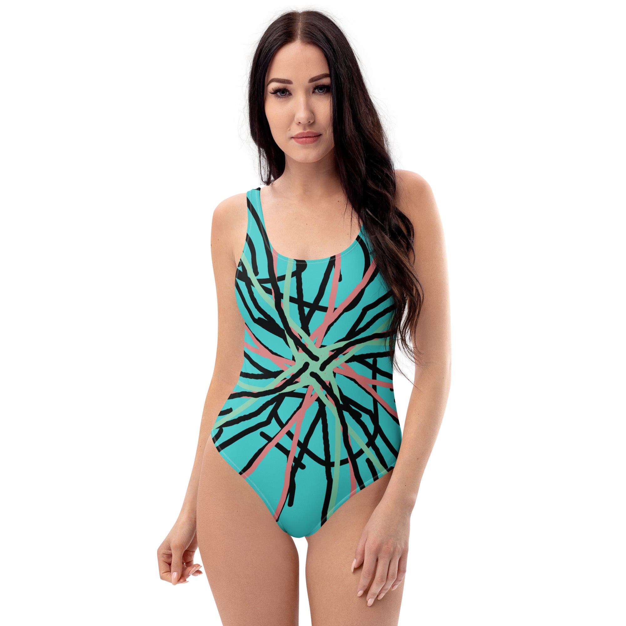 A woman smiling in a light blue one-piece swimsuit with a black, pink, and green abstract line print.