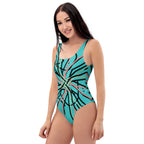 Full-body shot of a woman modeling a modern one-piece swimsuit with an intricate abstract pattern.