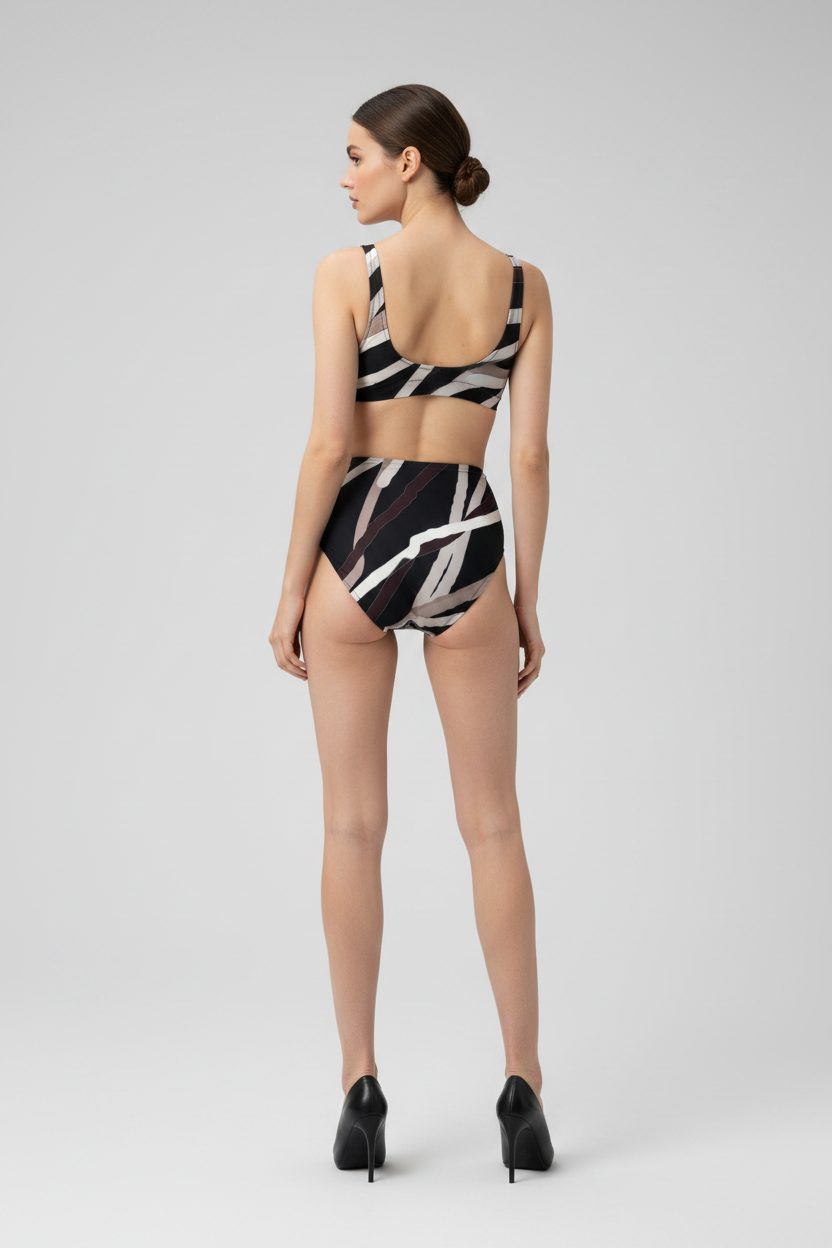 Woman wearing a black and white patterned swimsuit on a gray background