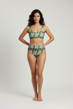 Woman wearing a green and white patterned bikini set on a plain background