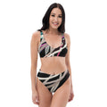 A woman smiling in a black, white, and gray abstract stripe high-waisted bikini.