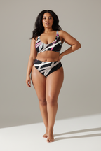 Woman wearing a colorful bikini set against a neutral background