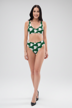 Woman wearing a green bikini with white floral patterns on a white background