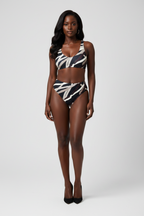 Woman wearing a black and white patterned bikini on a white background