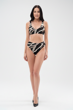 Woman wearing a black and white patterned bikini on a white background