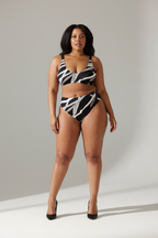 Woman wearing a zebra print swimsuit against a plain background