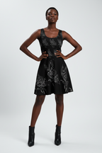 Woman wearing a black dress with white patterns on a white background