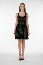 Woman wearing a black dress with white floral patterns on a white background
