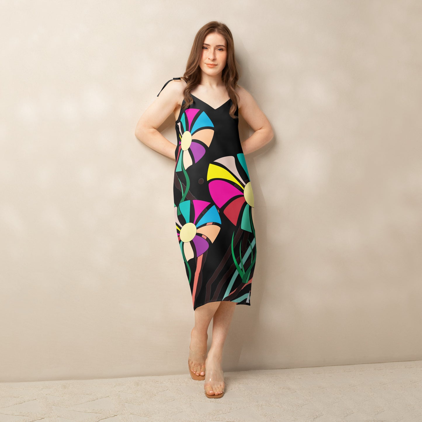Front view of a woman modeling a v-neck, sleeveless midi dress in dark green with large, multi-colored flower prints.