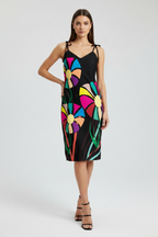 Woman wearing a black dress with colorful floral patterns on a white background