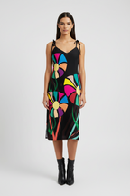 Woman wearing a black dress with colorful floral patterns on a white background