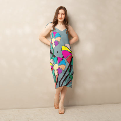 Front view of a woman modeling a v-neck, sleeveless midi dress in soft gray with large, multi-colored flower prints.