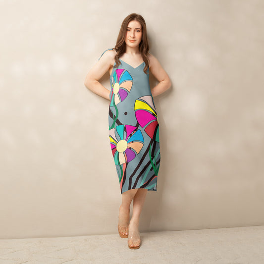 Front view of a woman modeling a v-neck, sleeveless midi dress in soft gray with large, multi-colored flower prints.