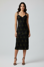 Woman wearing a black dress with a pattern on a white background
