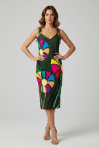 Woman wearing a colorful dress with a geometric pattern on a plain background