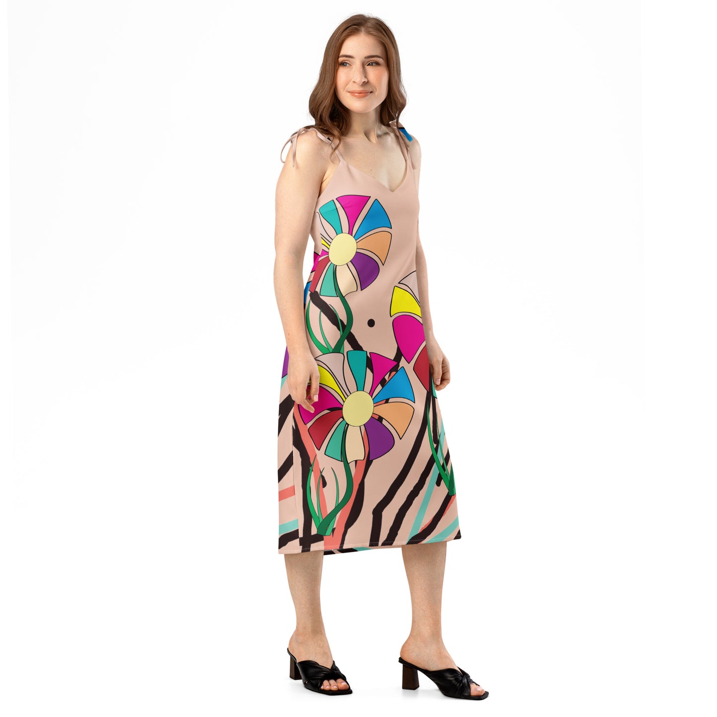 Full-length view of a peach midi dress with a colorful abstract floral pattern, featuring tie straps and a subtle side slit.