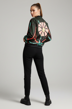 Person wearing a black jacket with colorful floral design and black pants on a gray background