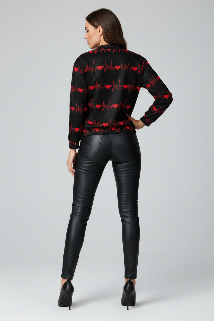 Woman wearing a black shirt with red heart patterns and black leather pants on a gray background