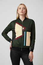 Woman wearing a green bomber jacket with geometric patterns on a light gray background