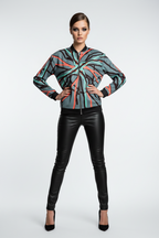 Model wearing a patterned top and black leather pants on a white background