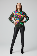Woman wearing a colorful jacket with geometric patterns on a plain background